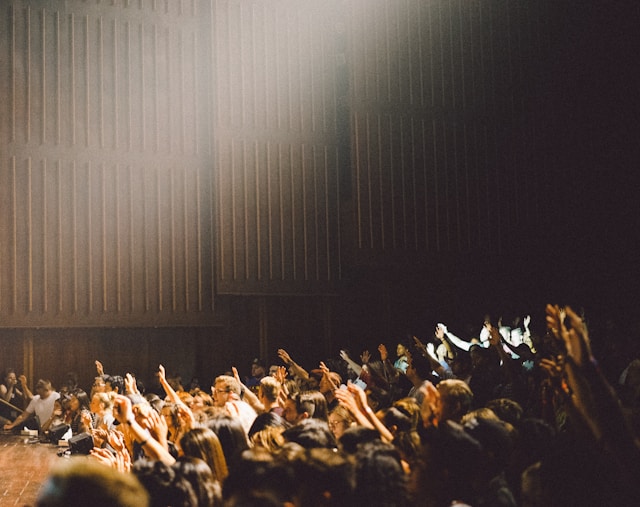 a crowd of people raising their hands to ask questions